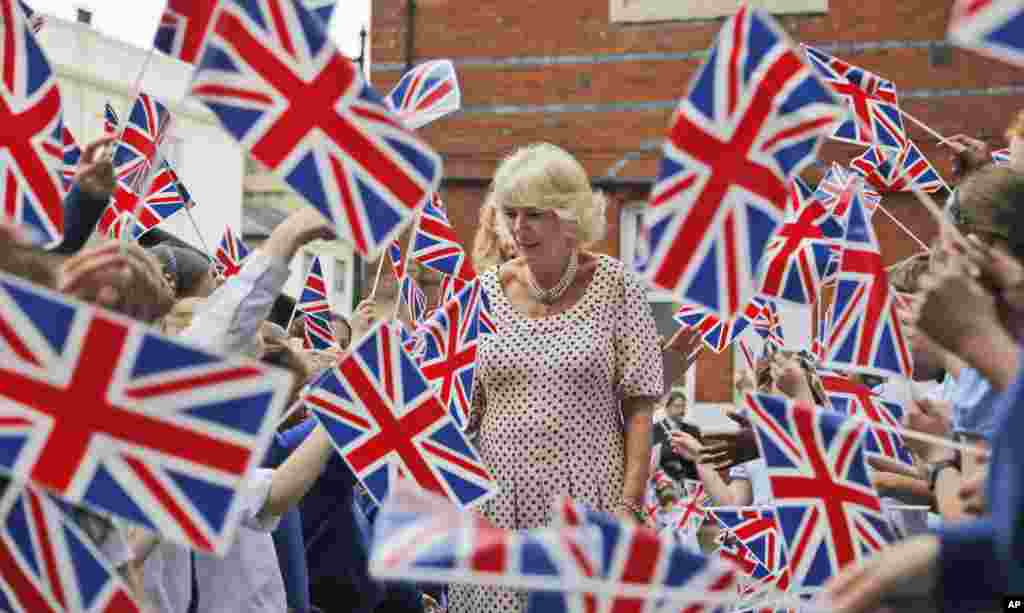 Children wave the Union Flag, as the Duchess of Cornwall visits St. Peter&#39;s Eaton Square Church of England Primary School in London.