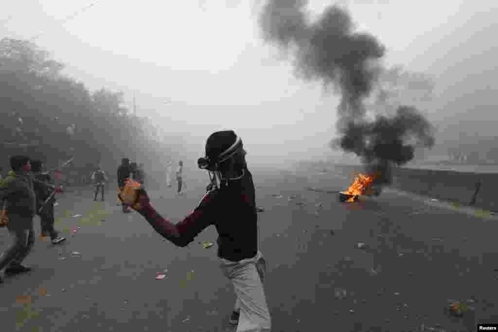 A pro-government activist throws a piece of brick toward activists of the Bangladesh Nationalist Party (BNP) during a clash in Dhaka December 9, 2012. Police fired rubber bullets and tear gas to disperse protesters staging blockades across Bangladesh on S