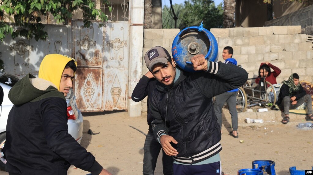 加沙民众带着煤气罐等待从埃及进入加沙的油罐车给充填煤气。（2023年11月25日）(photo:VOA)