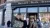 Students pose for a selfie outside the Harvard Book Store, March 9, 2017, in Cambridge, Mass. Readers have been flocking to classic works of dystopian fiction. Some have shot to the top of best-seller lists, including George Orwell's "1984" and Margaret A