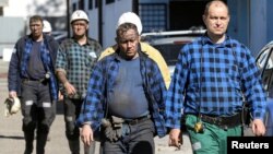 Miners walk outside the JSW mine, May 7, 2018, where others are missing underground after a strong quake hit the mine two days earlier in Jastrzebie Zdroj, Poland.