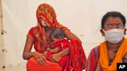 FILE — Women wait to receive the vaccine for COVID-19 in New Delhi, India, Friday, July 2, 2021.