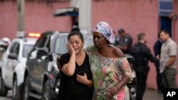Silvia Palmieri (izquierda), quien es madre de una maestra que sobrevivió a un ataque a puñaladas en la escuela Thomazia Montorosale es consolada por una amiga el lunes 27 de marzo de 2023 en Sao Paulo, Brasil.