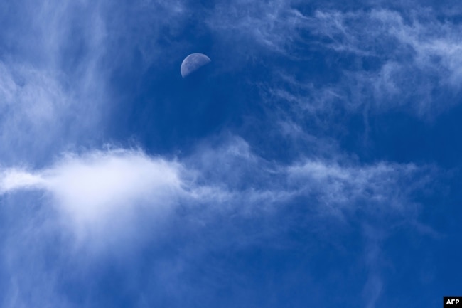 The moon is pictured during a cloudy day over Saint-Philbert-sur-Risle on August 8, 2023. (Photo by JOEL SAGET / AFP)