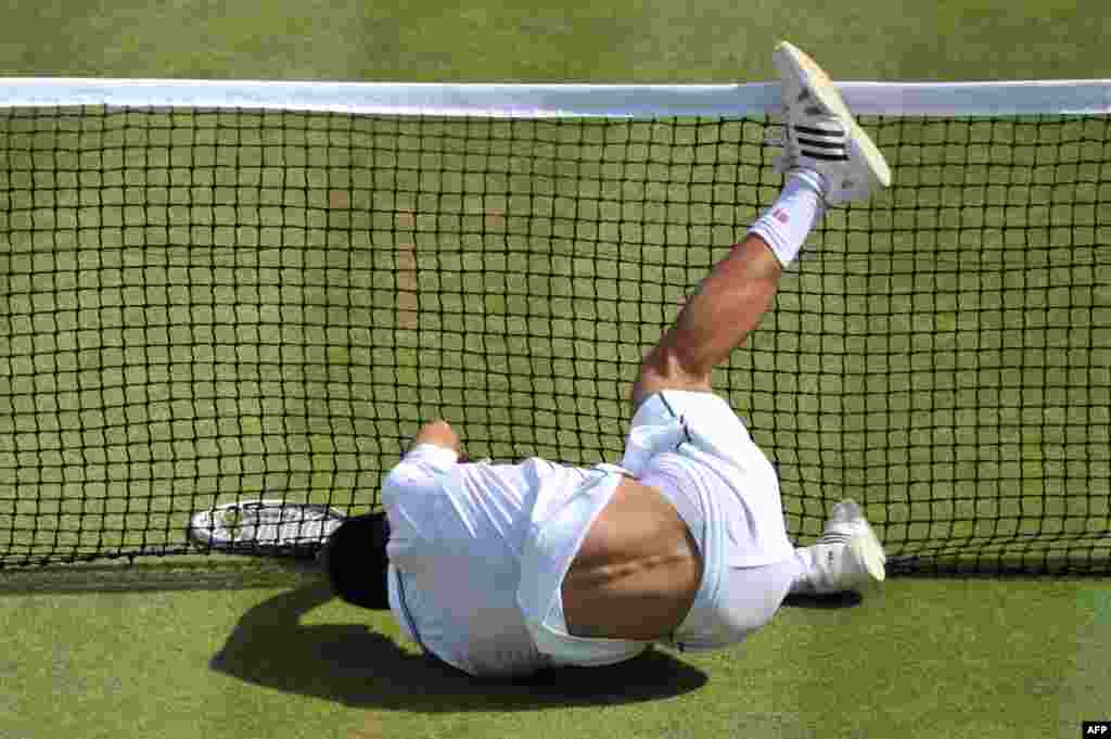 Serbia&#39;s Novak Djokovic falls into the net during the men&#39;s singles quarter-final match against Croatia&#39;s Marin Cilic on day nine of the 2014 Wimbledon Championships at the All England Tennis Club in Wimbledon, southwest London.