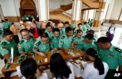 Appointed lawmakers who represent Myanmar's military mark their attendance for a regular session of lower house of Parliament Monday, July 25, 2016 in Naypyitaw, Myanmar.