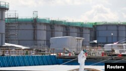 Seorang karyawan TEPCO di pembangkit tenaga nuklir Fukushima Daiichi di kota Okuma, prefektur Fukushima, Jepang