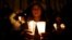 A supporter of the peace deal signed between the government and the Revolutionary Armed Forces of Colombia (FARC) rebels holds candles while attending a gathering at Bolivar Square during a "Silent March" in Bogota, Colombia, Oct. 5, 2016. 