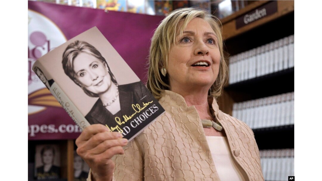 Former Secretary of State Hillary Rodham Clinton holds her memoir "Hard Choices" at Bunch of Grapes Bookstore, in Vineyard Haven, Massachusetts during a book signing event, Aug. 13, 2014.
