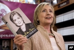 Former Secretary of State Hillary Rodham Clinton holds her memoir "Hard Choices" at Bunch of Grapes Bookstore, in Vineyard Haven, Massachusetts during a book signing event, Aug. 13, 2014.