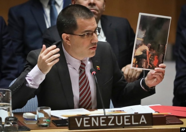 Venezuela Foreign Affairs Minister Jorge Arreaza shows picture he said represent opposition members initiating violence, during a meeting on Venezuela in the Security Council at U.N. headquarters, Feb. 26, 2019.