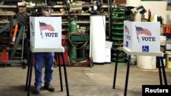 FILE - Voters cast their ballots at a polling station set up in a garage during the U.S. presidential election, near Fernald, Iowa, Nov. 8, 2016.