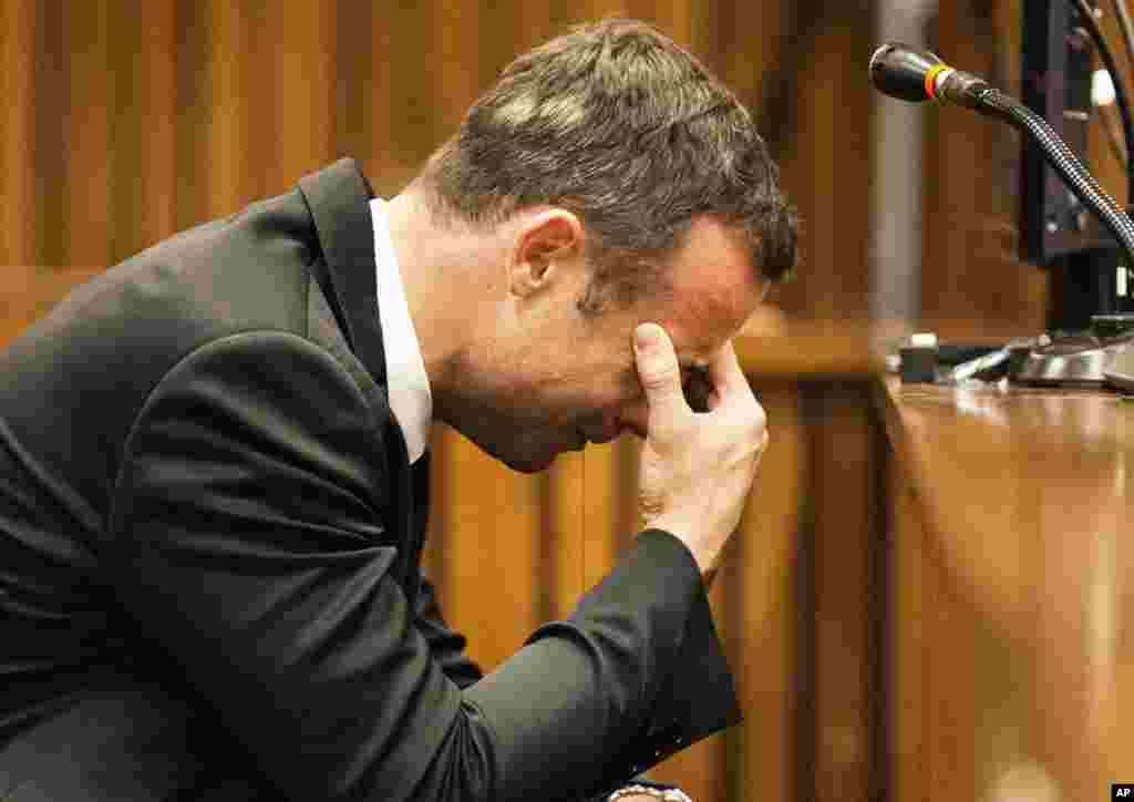 Oscar Pistorius puts his hand to his face while listening to evidence from a witness speaking about the morning of the shooting, Pretoria, March 6, 2014.