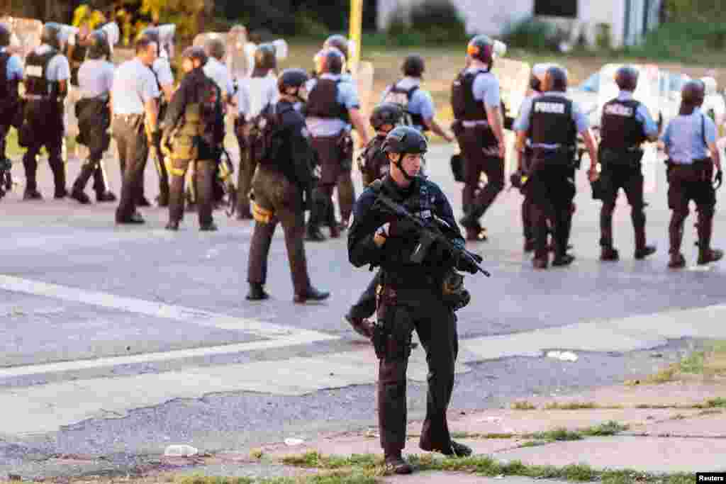 A police line blocks protesters who gathered after a black man was shot by police, St. Louis, Aug. 19, 2015.