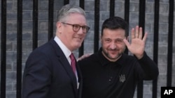 O primeiro-ministro britânico Keir Starmer, à esquerda, cumprimenta o Presidente da Ucrânia, Volodymyr Zelenskyy, em Downing Street, Londres, a 1 de março de 2025.