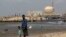 FILE - A man stands with his son on the beach near the Kudankulam nuclear power project in the southern Indian state of Tamil Nadu. 