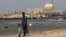FILE - A man stands with his son on the beach near the Kudankulam nuclear power project in the southern Indian state of Tamil Nadu. 