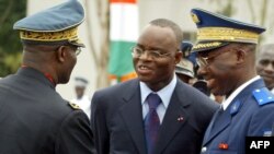 Le ministre de la Défense de la Côte d'Ivoire Moïse Lida Kouassi, au centre, rencontre le général en chef de l'armée Mathias Doue, à gauche, et le chef de la gendarmerie Touvoly, à droite, lors des célébrations pour l'indépendance du pays, le 07 août 200