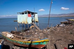 FILE - A man enters an outhouse erected near the coastline of the Cite Soleil slum, in Port-au-Prince, Haiti, Dec. 25, 2016.