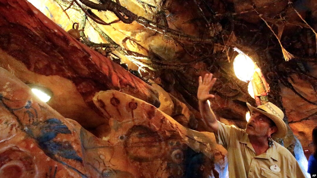In this April 29, 2017 photo, Joe Rohde, design and production leader for Pandora-World of Avatar land attraction, explains about the caverns and the meaning of the cave drawings of the Na'vi, the native inhabitants of the planet Pandora at Disney's Animal Kingdom theme park at Walt Disney World in Lake Buena Vista, Florida. 