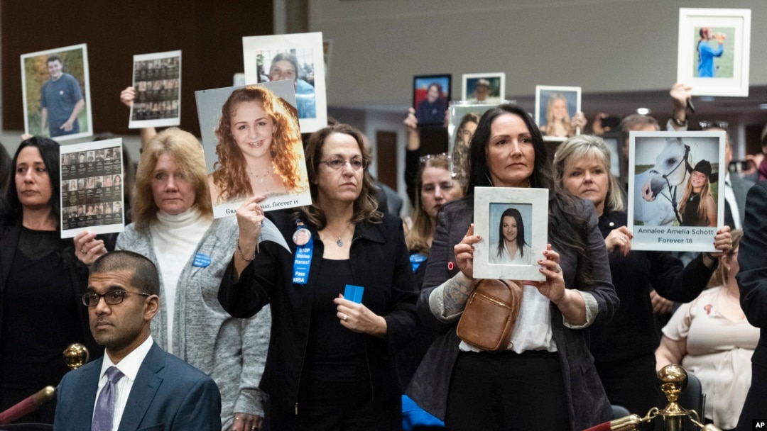 People in the audience hold up photos of their loved ones during the Senate Judiciary Committee's hearing on online child safety on Capitol Hill, Jan. 31, 2024 in Washington.