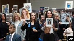 People in the audience hold up photos of their loved ones during the Senate Judiciary Committee's hearing on online child safety on Capitol Hill, Jan. 31, 2024 in Washington.