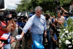 Dallas Mayor Mike Rawlings visits a makeshift memorial of police cars, in honor of the slain Dallas police officers, in front of their headquarters in Dallas, July 9, 2016.