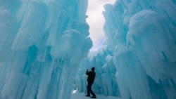 Seseorang berjalan melalui gua dan lapisan salju di &quot;Ice Castles&quot; di North Woodstock, New Hampshire. (AFP)&nbsp;