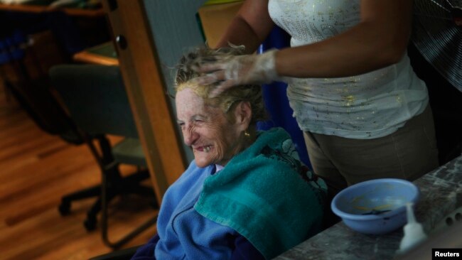 FILE - An Alzheimer's patient has her hair done inside the Alzheimer foundation in Mexico City April 19, 2012. Alzheimer’s slowly attacks areas of the brain needed for memory, reasoning, communication and basic, daily tasks. 