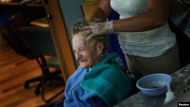 FILE - An Alzheimer's patient has her hair done inside the Alzheimer foundation in Mexico City April 19, 2012. Alzheimer’s slowly attacks areas of the brain needed for memory, reasoning, communication and basic, daily tasks. 