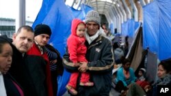 FILE - Families hoping to seek asylum in the United States wait on the bridge connecting Reynosa, Mexico, to Hidalgo, Texas, March 15, 2019.