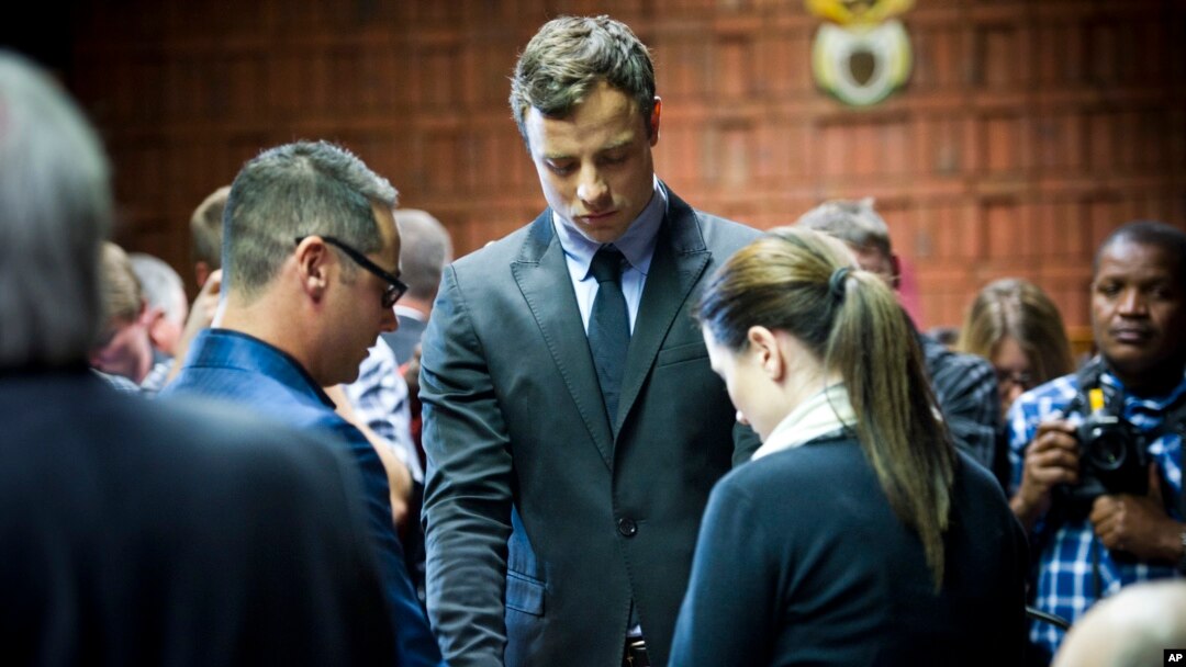 Oscar Pistorius ariko ararira, igihe yariko arasenga ri kumwe na mushiwe Aimee hamwe na mwenewabo, Carl muri sentare yo mu gisagara ca Pretoria, kw'igenekerezo rya 19 ry'ukwezi kw'umunani