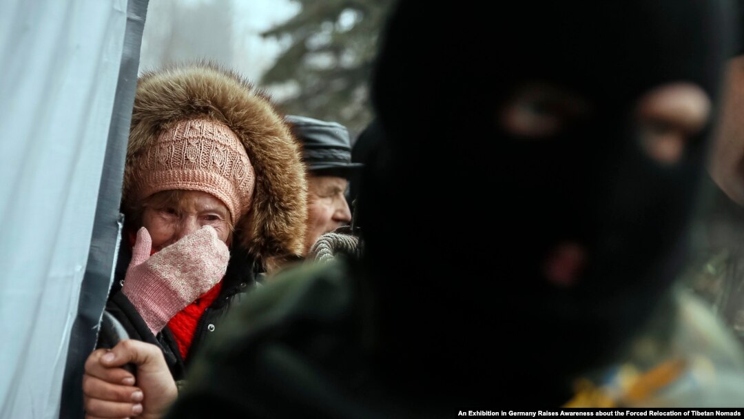 FILE - A woman cries as she waits for humanitarian aid as a Ukrainian serviceman stands nearby in Debaltseve, eastern Ukraine, Feb. 6, 2015. 