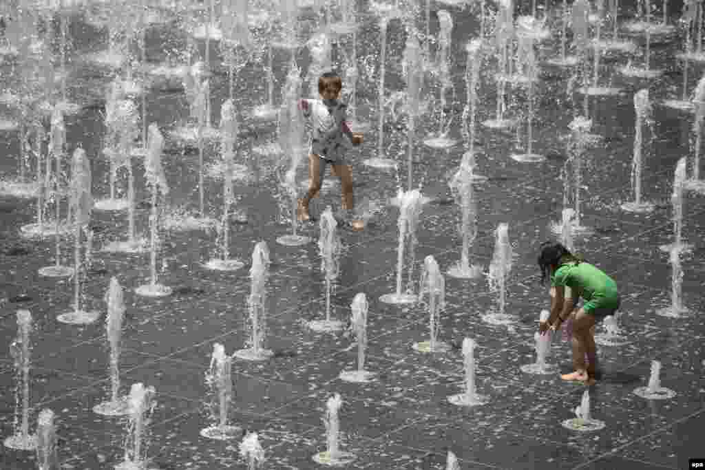 Young Israeli children play in a water fountain on a hot day near the Tower of David in the Old City of Jerusalem.