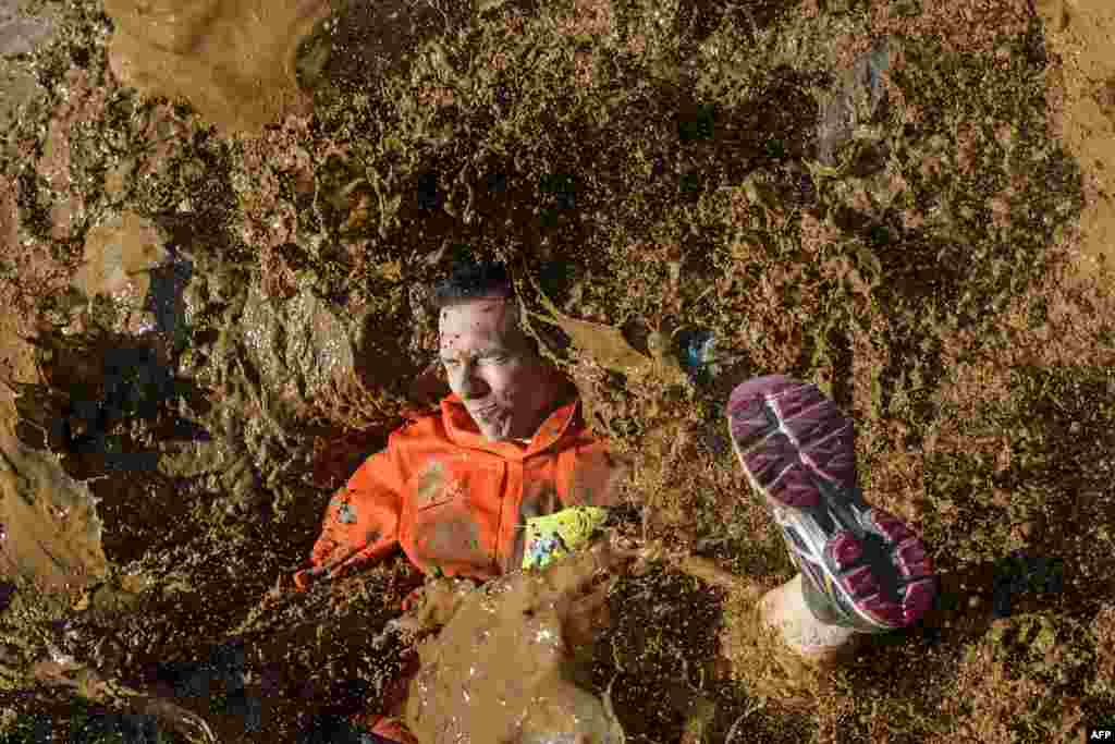 A competitor lands in mud in the &quot;Barjot Run&quot; obstacle race in Biere, western Switzerland, April 8, 2017.