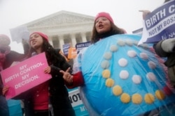 FILE - In this March 25, 2015, photo, protesters demonstrate in front of the Supreme Court, as the court heard arguments in the challenges to a US health care law requiring businesses to provide employees with insurance that includes contraceptives.