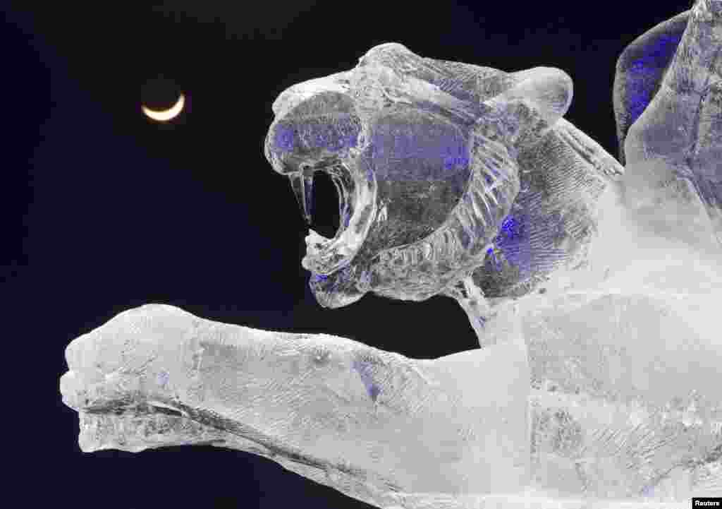 The crescent moon is seen behind an ice sculpture during ice and snow sculptures festival at the &lsquo;Eight Lakes&rsquo; Park-Resort outside Almaty, Kazakhstan. 