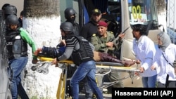 A victim is being evacuated by rescue workers outside the Bardo museum in Tunis, Wednesday, March 18, 2015 in Tunis, Tunisia. 