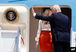 President Donald Trump, accompanied by first lady Melania Trump, waves as they board Air Force One at Andrews Air Force Base, Maryland, May 19, 2017, prior to his departure on his first overseas trip.