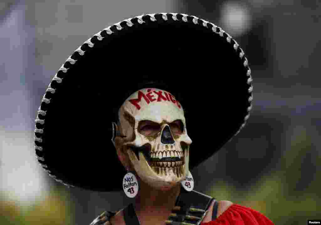 A demonstrator wearing a skull mask takes part in a protest in Mexico City to mark the eleven-month anniversary of their disappearance. The students' disappearance on the night of Sept. 26, 2014, in the southwestern city of Iguala triggered massive protests in Mexico and calls for justice. 