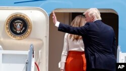 President Donald Trump, accompanied by first lady Melania Trump, waves as they board Air Force One at Andrews Air Force Base, Maryland, May 19, 2017, prior to his departure on his first overseas trip as president.