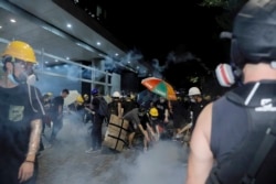 Protesters pour water on tear gas canisters at the Legislative Council in Hong Kong, during the early hours on July 2, 2019.