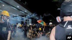 Protesters pour water on tear gas canisters at the Legislative Council in Hong Kong, during the early hours on July 2, 2019.