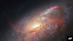 FILE - This file image made by the NASA/ESA Hubble Space Telescope shows M106 with additional information captured by amateur astronomers.