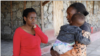 Pendiri sekolah menengah Serene Haven, Elizabeth Wanjiru berbicara dengan Josephine Wanjiru, 19, yang menggendong anaknya di luar asrama di sekolah menengah Serene Haven. (Foto: REUTERS/Monicah Mwangi)