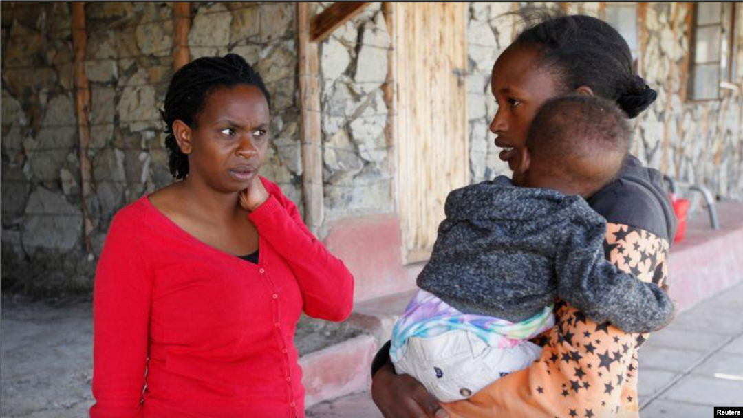Pendiri sekolah menengah Serene Haven, Elizabeth Wanjiru berbicara dengan Josephine Wanjiru, 19, yang menggendong anaknya di luar asrama di sekolah menengah Serene Haven. (Foto: REUTERS/Monicah Mwangi)