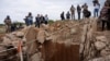 FILE - People watch as Senzo Mchunu, South African police minister (not pictured), inspects outside the mineshaft where it is estimated that illegal miners are believed to be hiding underground, in Stilfontein, Nov. 15, 2024.