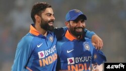 বিশাখাপত্তনমে ভারত ও ওয়েস্ট ইন্ডিজের মধ্যে দ্বিতীয় একদিনের আন্তর্জাতিক (ওডিআই) ক্রিকেট ম্যাচের পর ভারতের অধিনায়ক বিরাট কোহলি সতীর্থ মহম্মদ শামির সঙ্গে জয়ের উল্লাসে মেতে উঠেন।১৮ ডিসেম্বর ২০১৯। (ছবি-এএফপি) 