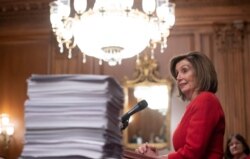 US Speaker of the House Nancy Pelosi speaks alongside a stack of legislation the House has passed as she holds a press conference with fellow Democrats at the US Capitol in Washington, DC, December 19, 2019.
