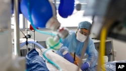 Personal médico atiende a un paciente con COVID-19 en la unidad de cuidados intensivos del Hospital Universitario de Estrasburgo, Francia, el 13 de enero de 2022.